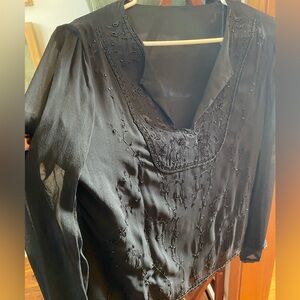 Effortlessly chic black long-sleeve top, featuring bead detail and open V neck